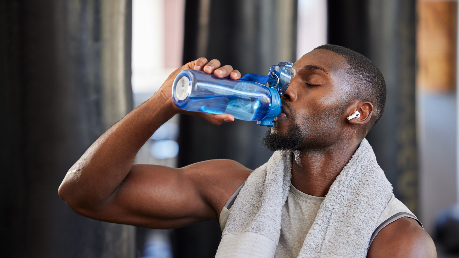 Athlete hydrating after a workout illustrating peptides vs steroids for exercise recovery, muscle repair, endurance, and post-workout performance.